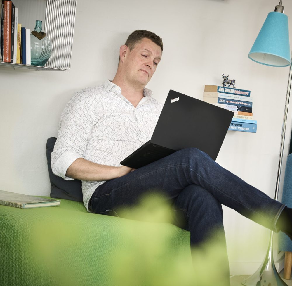 Kent Nielsen, grundlægger af KentiQ, arbejder med laptop i afslappede omgivelser